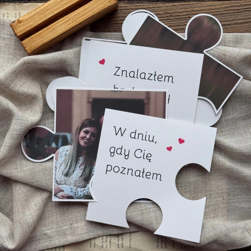 Kilka puzzli oraz drewienko z zestawu prezentowane na ozdobnym tle
