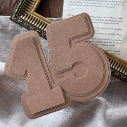 Baza 15 z wzornikiem – ujęcie na tle ramki, lnu i książki.