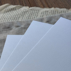 Zbliżenie na biały papier fakturowany RYPS - wyraźnie widać prążkowaną fakturę.