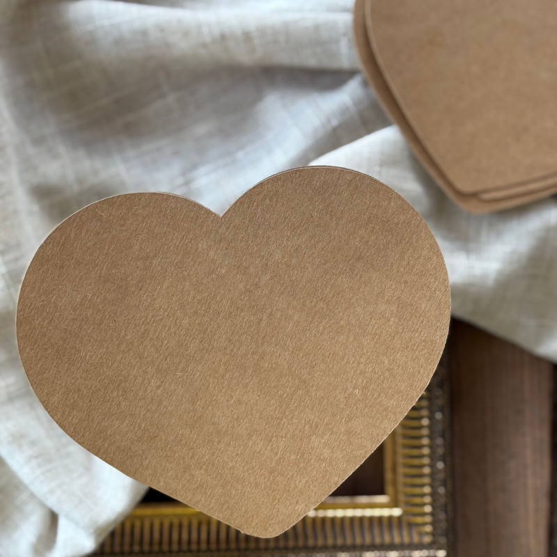 Baza i wzorniki w kształcie serca z papieru kraftowego, rozłożone na ozdobnym tle.