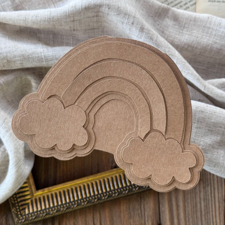 Baza i wzorniki w kształcie tęczy, wykonane z papieru kraftowego, ułożone na sobie na ozdobnym tle.