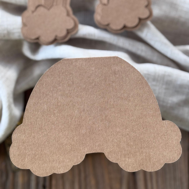 Baza kartki w kształcie tęczy oraz wzorniki z papieru kraftowego, rozłożone na dekoracyjnym tle.