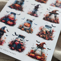 Zbliżenie na wydrukowany arkusz A4 z 12 grafikami przedstawiającymi halloweenowe słoiki, gotowy do wycięcia.