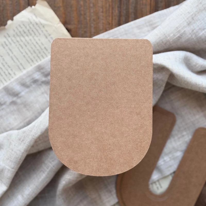 Baza do kartki handmade w kształcie litery U oraz papierowe wzorniki ułożone na ozdobnym tle.