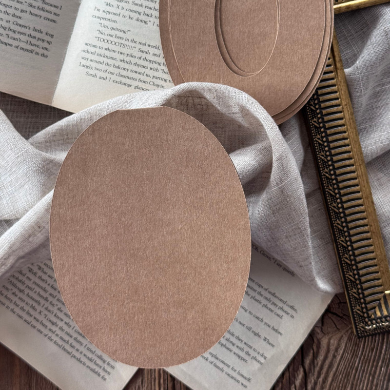 Złożona baza kraftowa w kształcie cyfry 0 na ozdobnym tle z książką i ramką, wzorniki widoczne w tle kompozycji